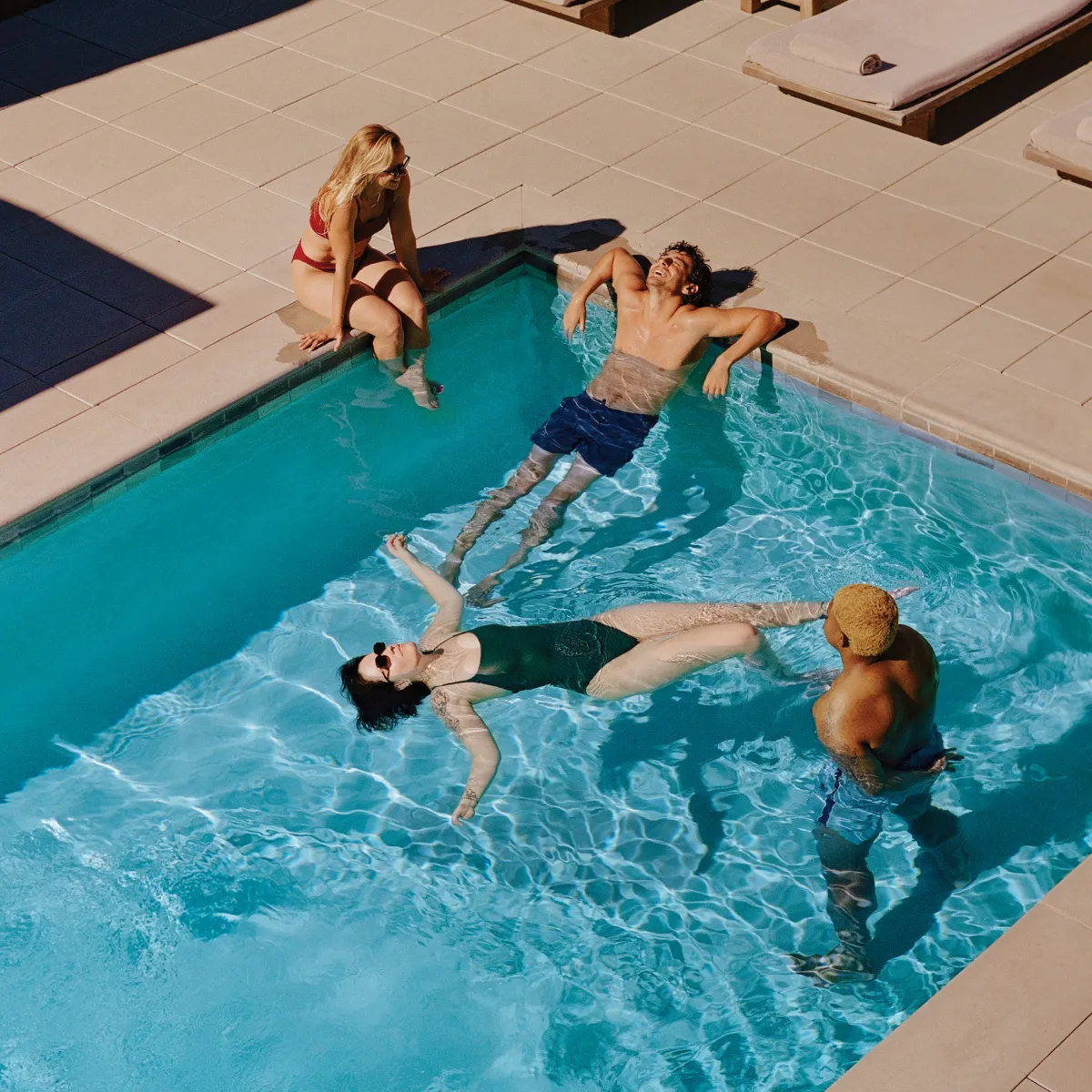 Friends enjoying a sunny resort pool